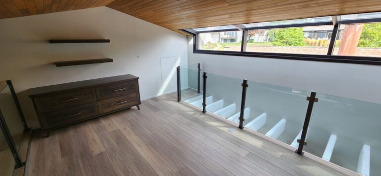 Renovated interior with wood ceiling and glass stair railing