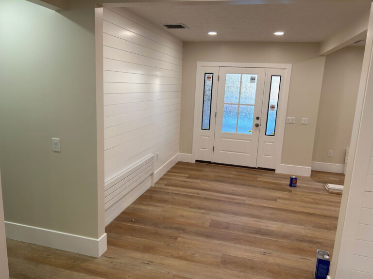 Entryway remodel with shiplap wall and wood flooring